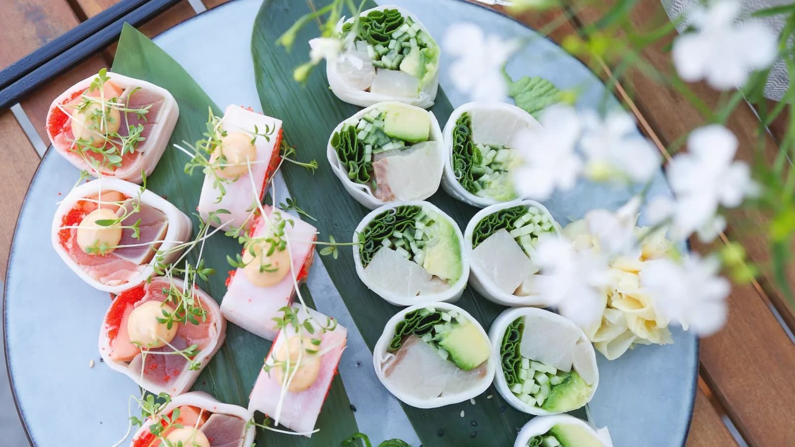 Foods to avoid during pregnancy: Overhead view of a sushi platter with raw fish rolls on a wooden table