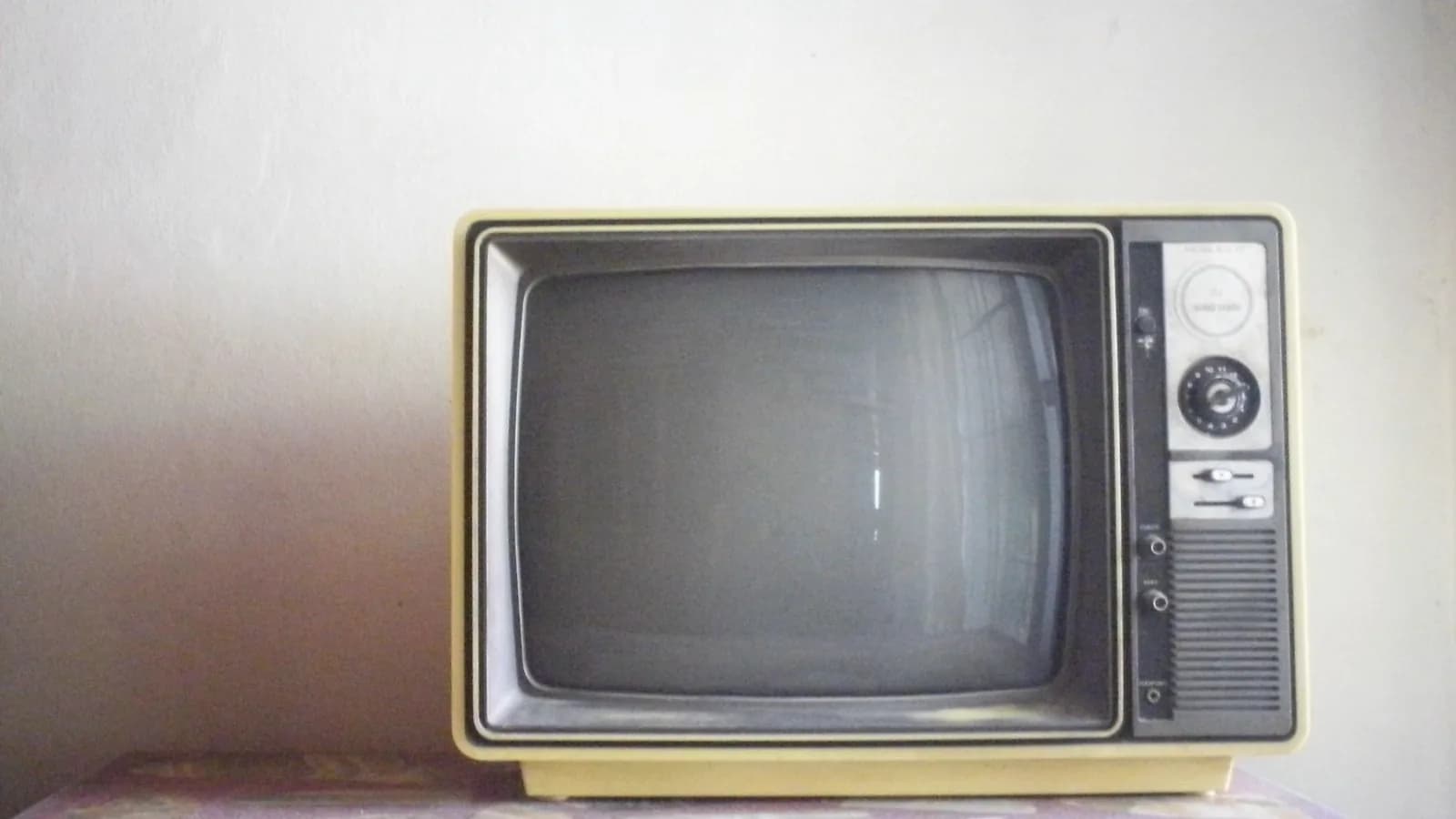 History of ultrasound technology: Small vintage television set on a shelf against a soft cream wall