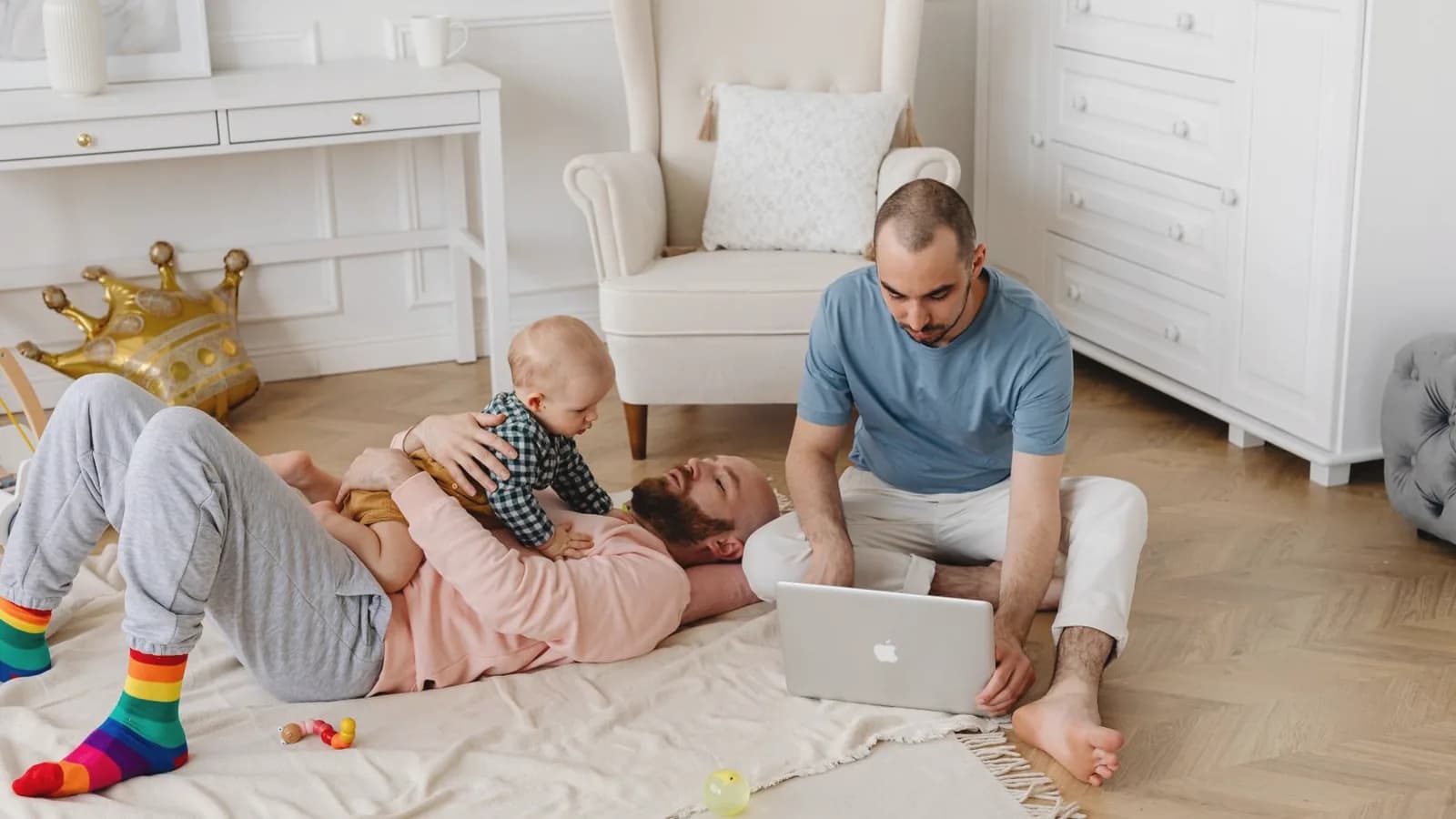 Including family in the pregnancy journey: Parents and a baby playing together on a cozy rug in a bright home