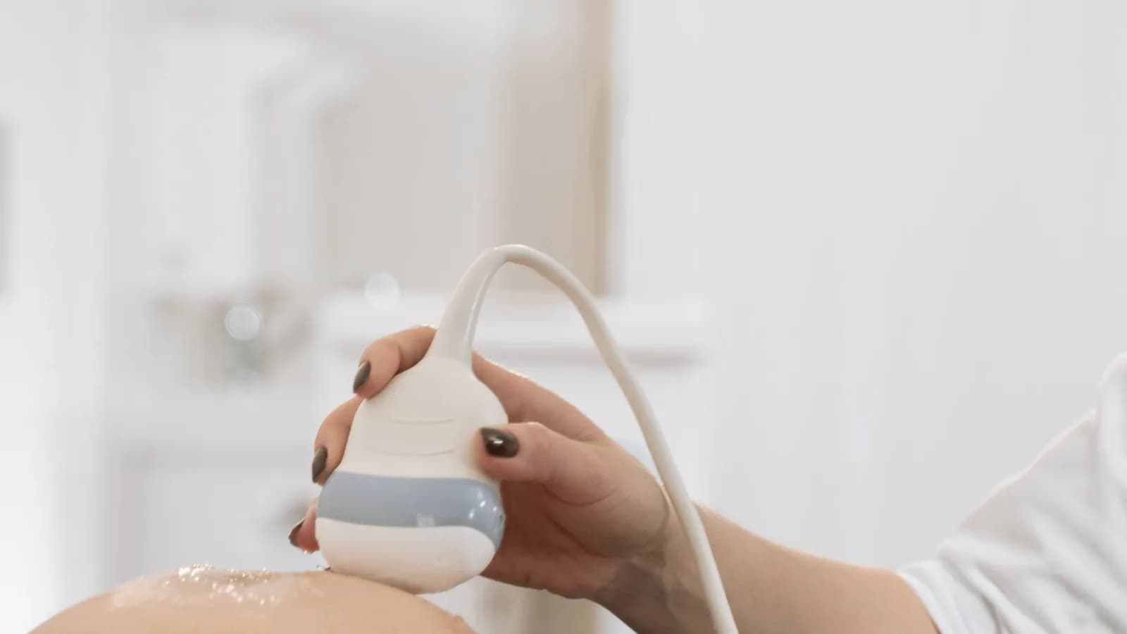 Nub theory gender prediction: Ultrasound probe on a pregnant belly during a scan at a clinic