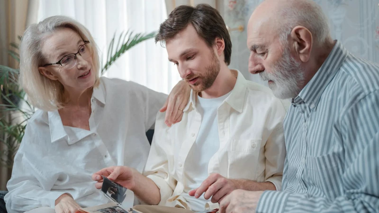 Ultrasound keepsakes for baby's first photos: Three generations of a family looking through a photo album together in a