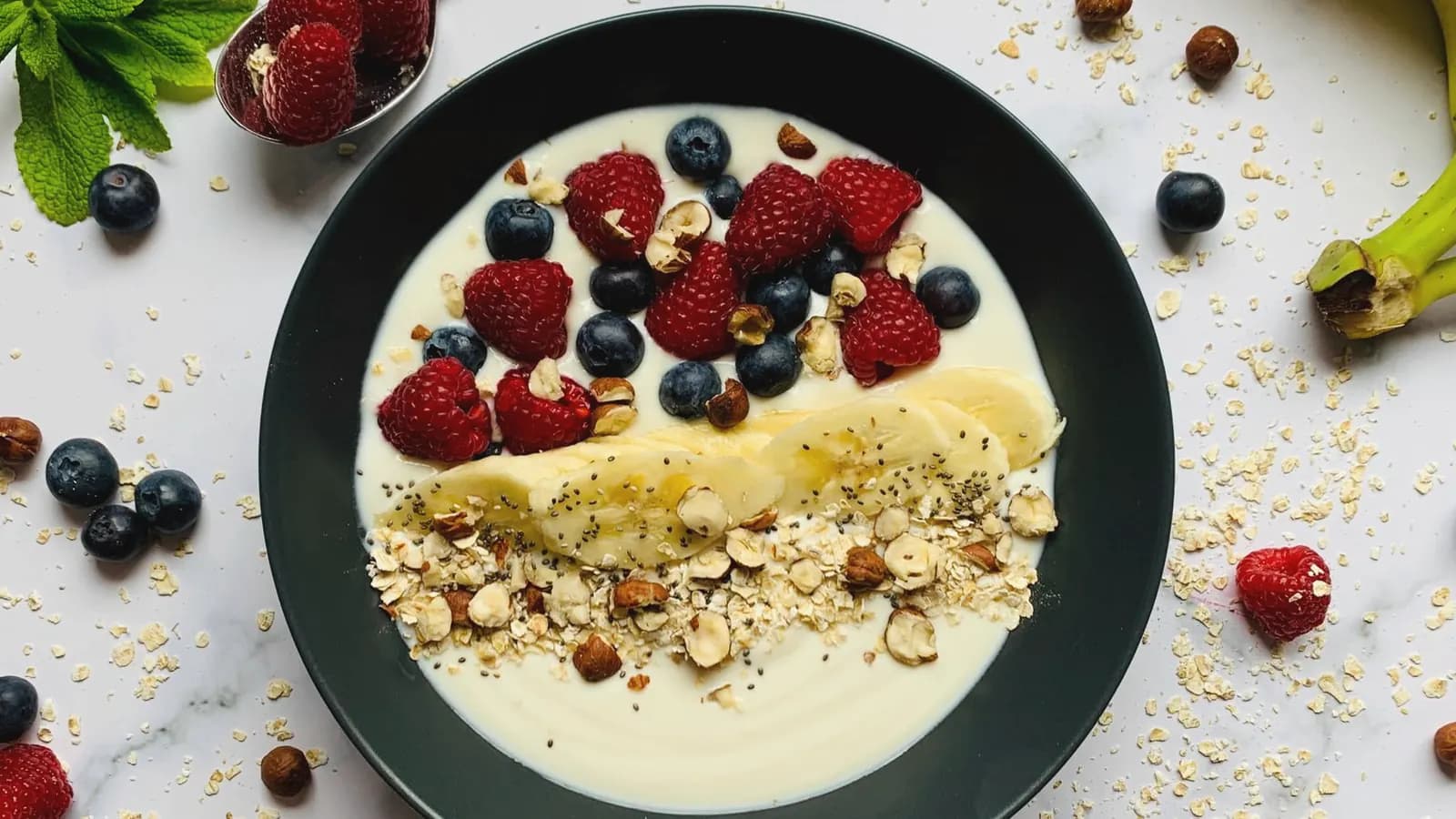 What to eat before an ultrasound: Yogurt breakfast bowl topped with fresh berries, banana slices, oats and hazelnuts on a