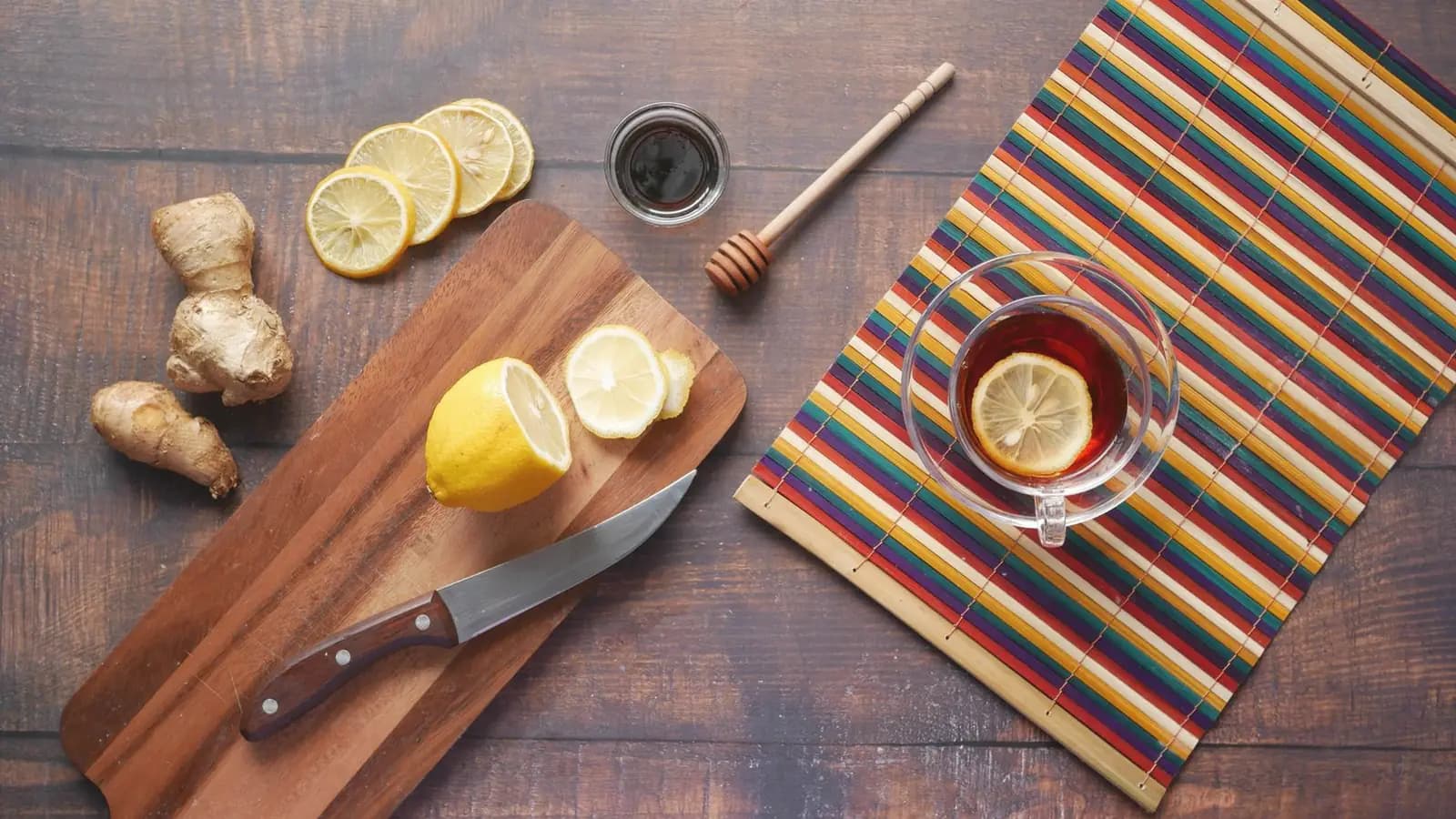 What to eat with morning sickness: Ginger, lemon slices and a cup of lemon tea on a rustic wooden table