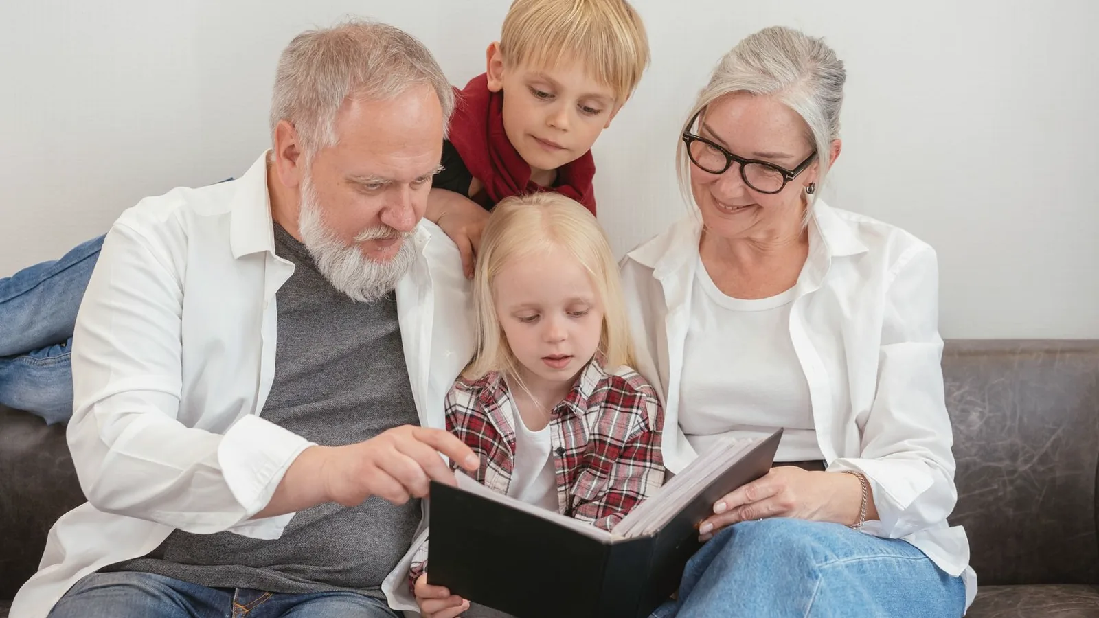 How to preserve ultrasound keepsakes: Family gathered on a sofa looking through a photo album together