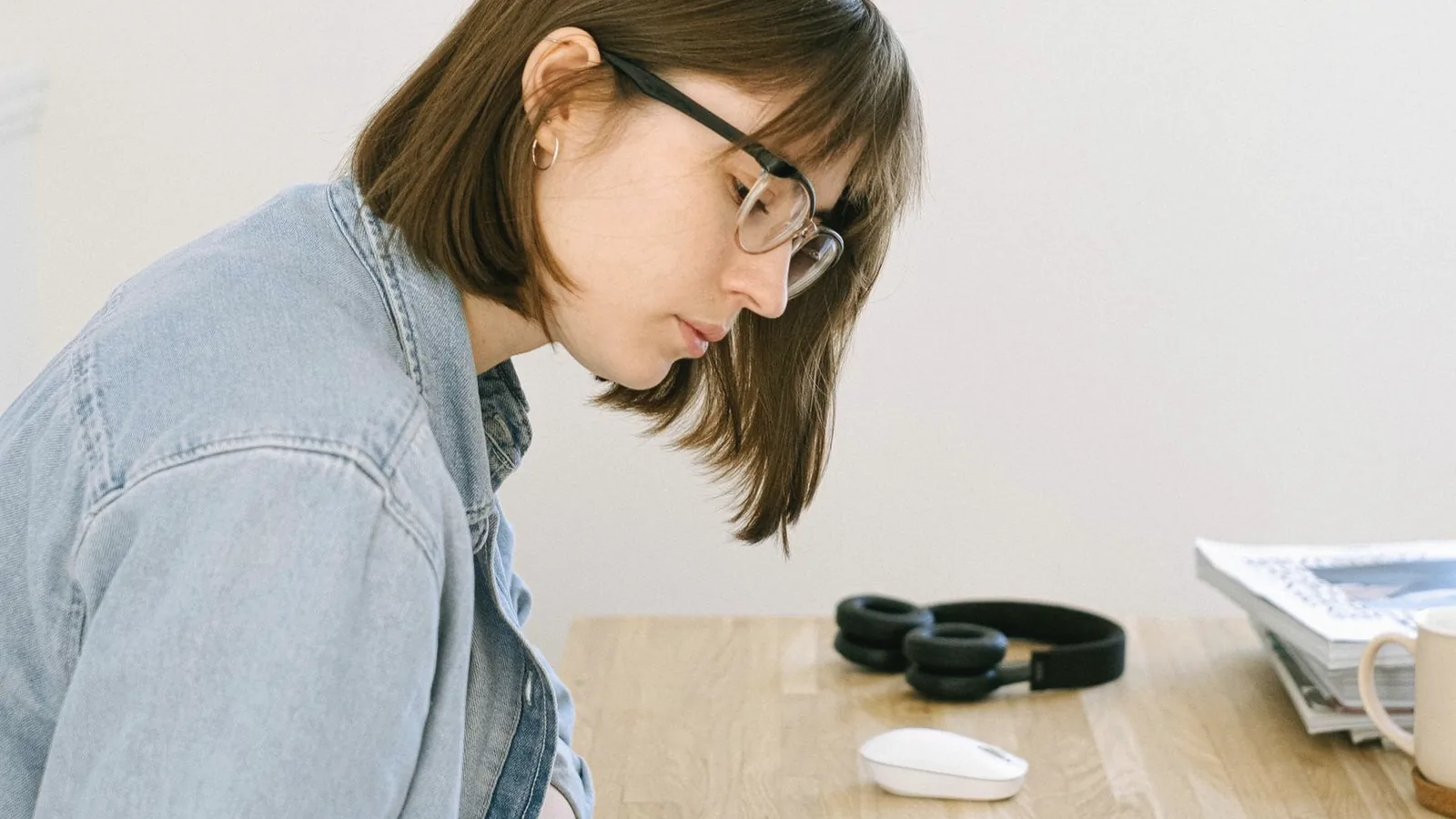 Pre appointment checklist for a 3D ultrasound: Young woman writing a list in a notebook at a bright wooden desk