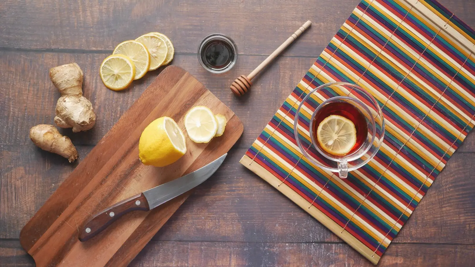 What to eat with morning sickness: Ginger, lemon slices and a cup of lemon tea on a rustic wooden table